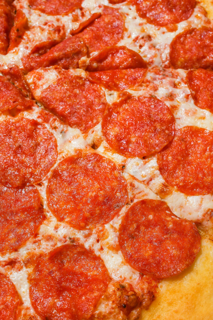 Close-up of Domino's pepperoni pizza with melted cheese crispy pepperoni and golden crust wallpaper