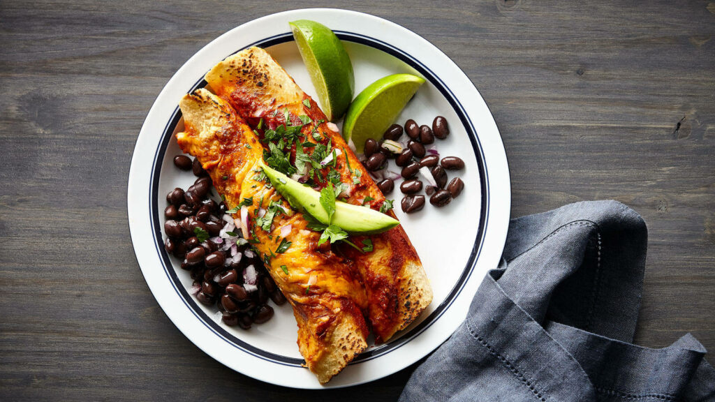Delicious Enchiladas with Cheese & Avocado on Rustic Table Wallpaper