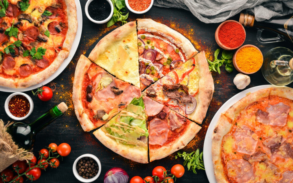 Fantastic Stagioni pizza sliced with fresh toppings on rustic table for delicious food wallpaper