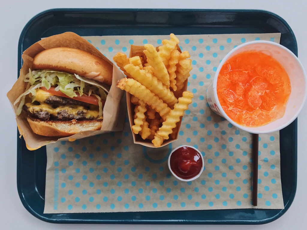 Juicy Cheeseburger Meal with Fries & Soda on Wallpaper Background