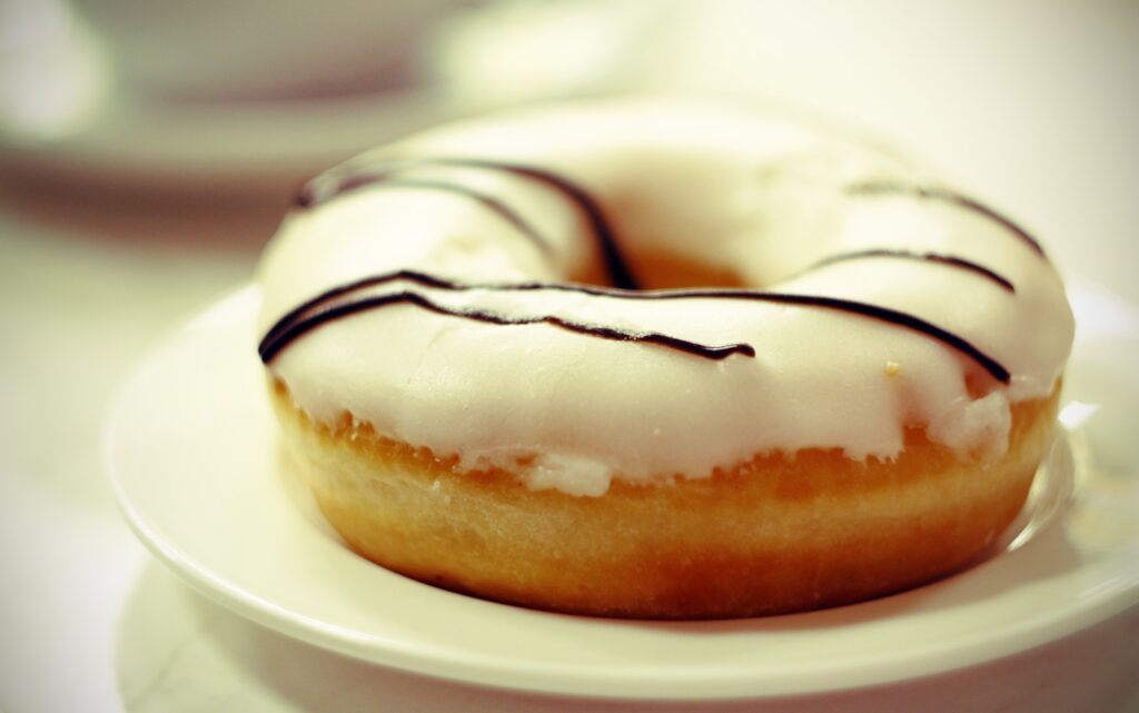 Chocolate Drizzled Glazed Donut on White Plate - Delicious Wallpaper