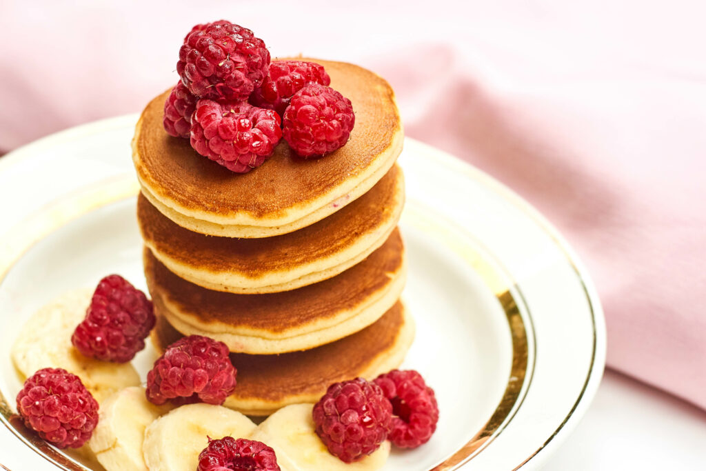 Delicious Golden-Brown Pancakes with Raspberries & Bananas Wallpaper