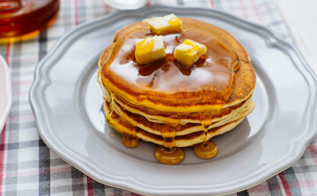 Golden Pancakes with Butter & Maple Syrup on Grey Plate - Wallpaper