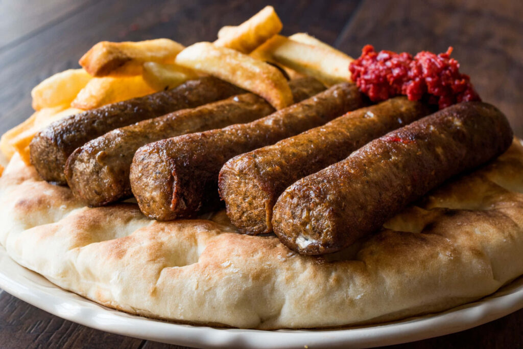 Grilled Ćevapi on Flatbread with Fries - Delicious Wallpaper Background
