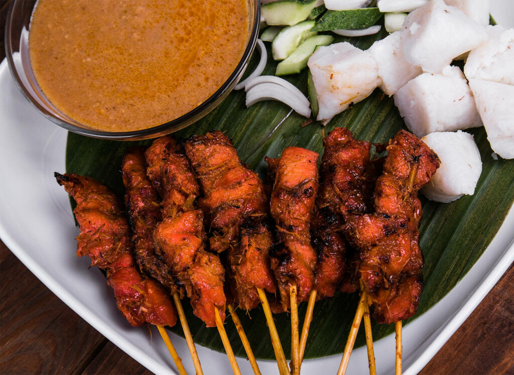 Delicious Grilled Pork Satay Wallpaper with Peanut Sauce & Rice Cakes