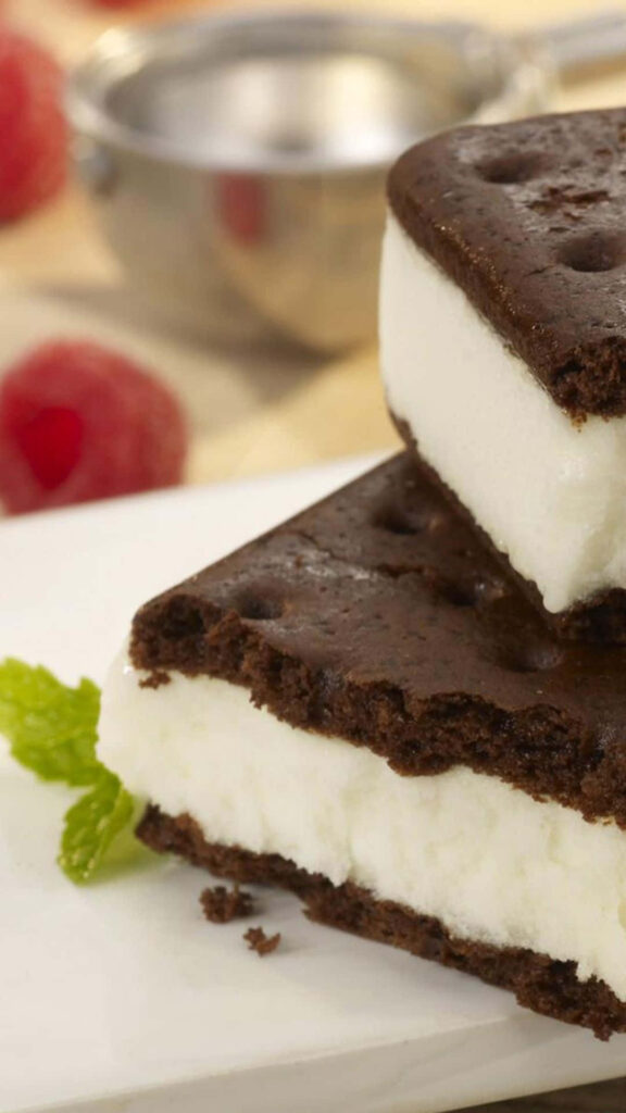 Drool-worthy Ice Cream Sandwich showcased amidst Desserts Delight in Blurred Background Wallpaper