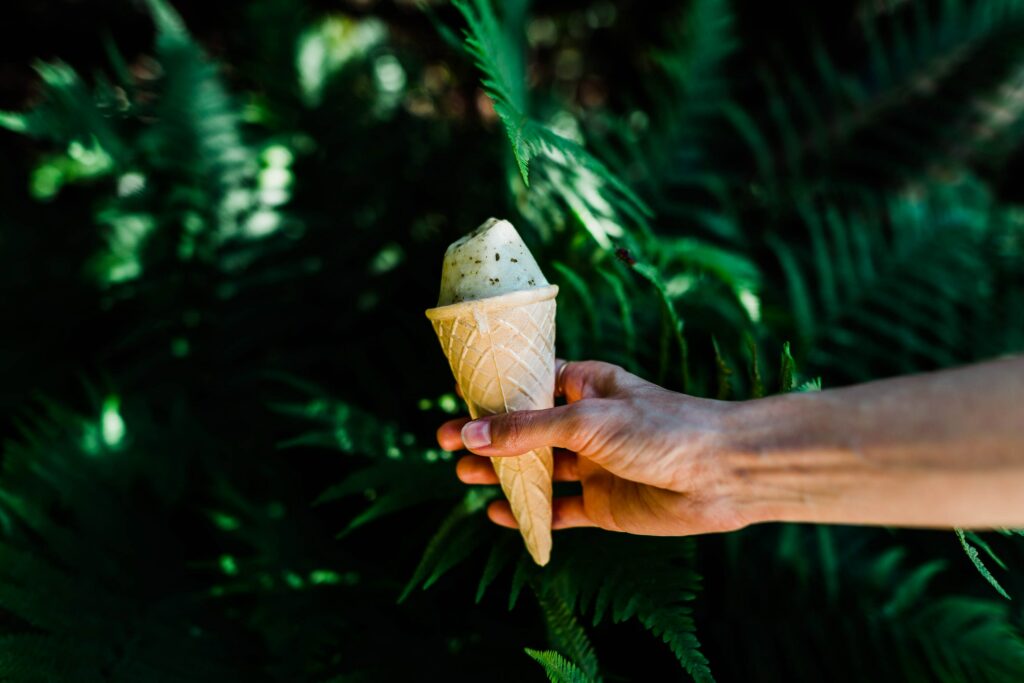 Delicious Ice Cream Cone Wallpaper Against Lush Green Backdrop