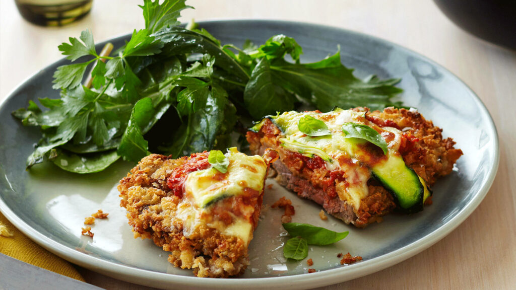 Delicious Italian Parmigiana Wallpaper with Fresh Salad Background