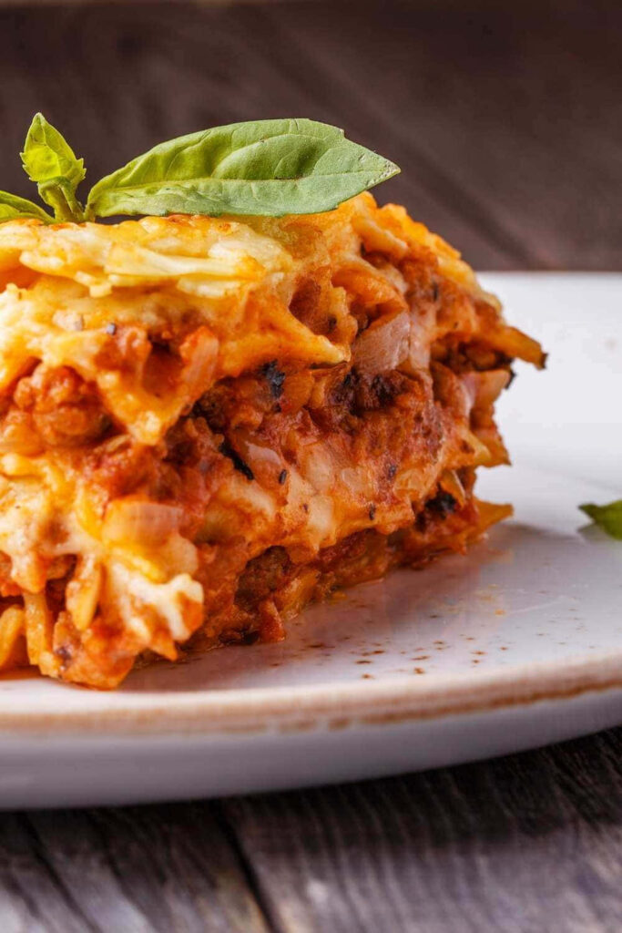 Delicious Lasagna Alla Bolognese Close-Up on Rustic Plate Wallpaper
