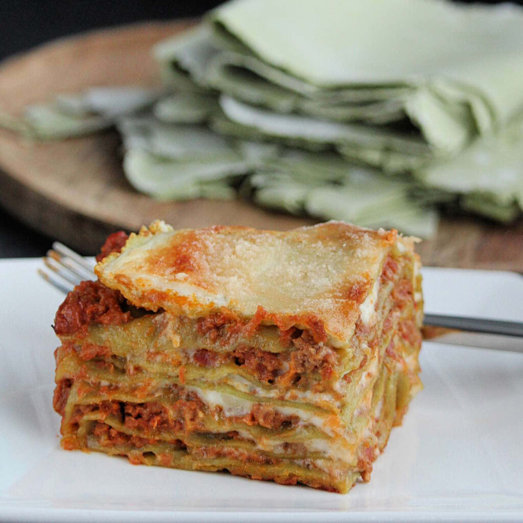 Delicious Lasagna Slice: Layers of Pasta & Cheese on White Plate Wallpaper
