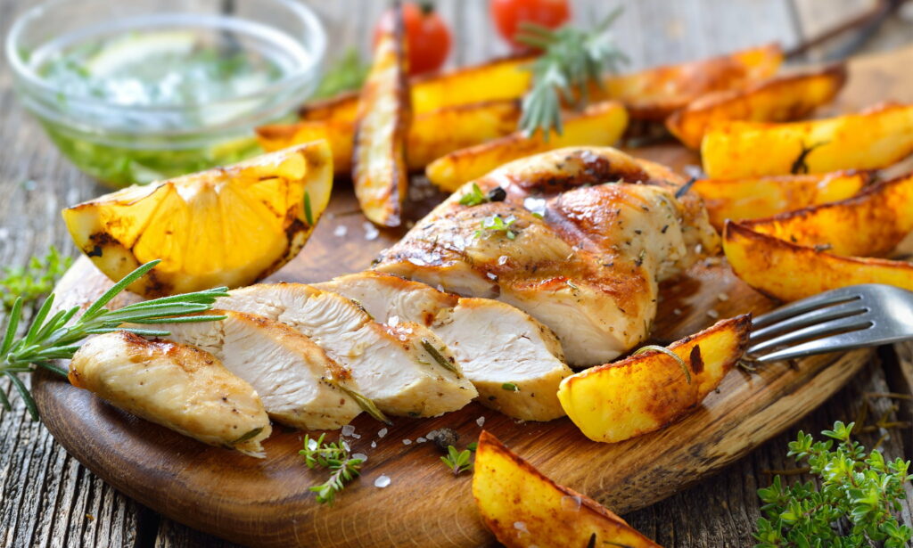 Scrumptious Meat Delight: Sizzling Chicken and Potato Feast -HD Wallpaper