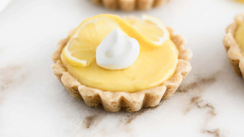 Delicious Mini Pie with Yellow Tart and Fluffy Whipped Cream - A Tempting Treat to Savor! Wallpaper