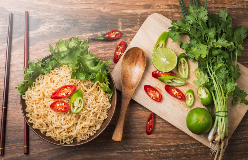 Vibrant Noodle Bowl Wallpaper: Fresh Ingredients in a Kitchen Setup