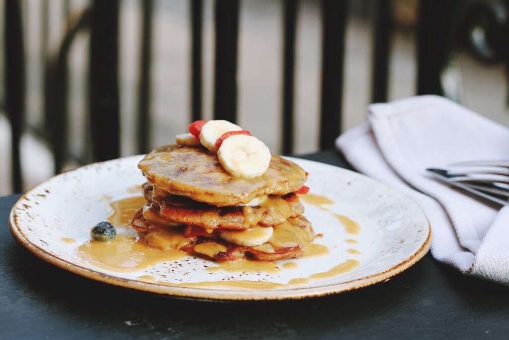 Delicious Pancakes with Bananas, Cream, and Berries - Rustic Wallpaper