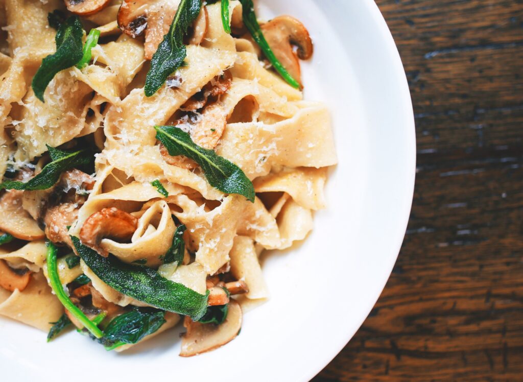 Delicious Pasta with Veggies & Cheese on Rustic Wooden Table Wallpaper