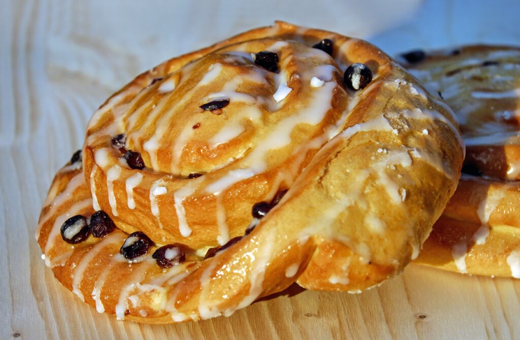 Delicious Pastry Wallpaper: Raisin Buns on Light Wood Background
