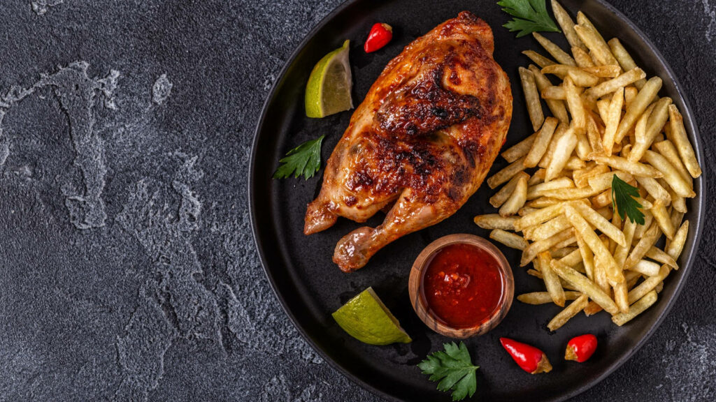 Delicious Peri Peri Chicken with Fries & Herbs on Dark Wallpaper
