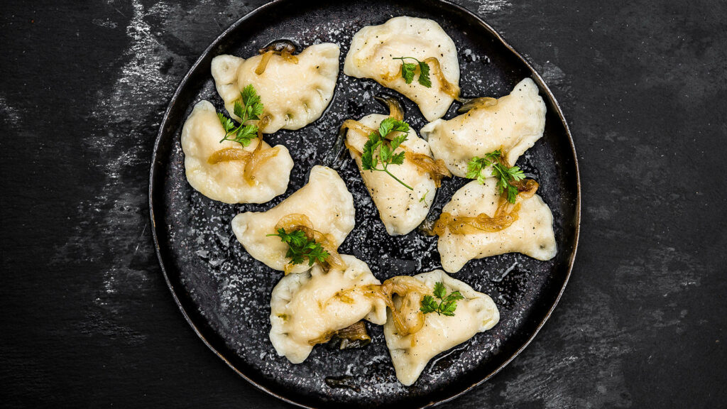 “Delicious Pierogi on Black Plate with Herbs & Onions - Wallpaper”