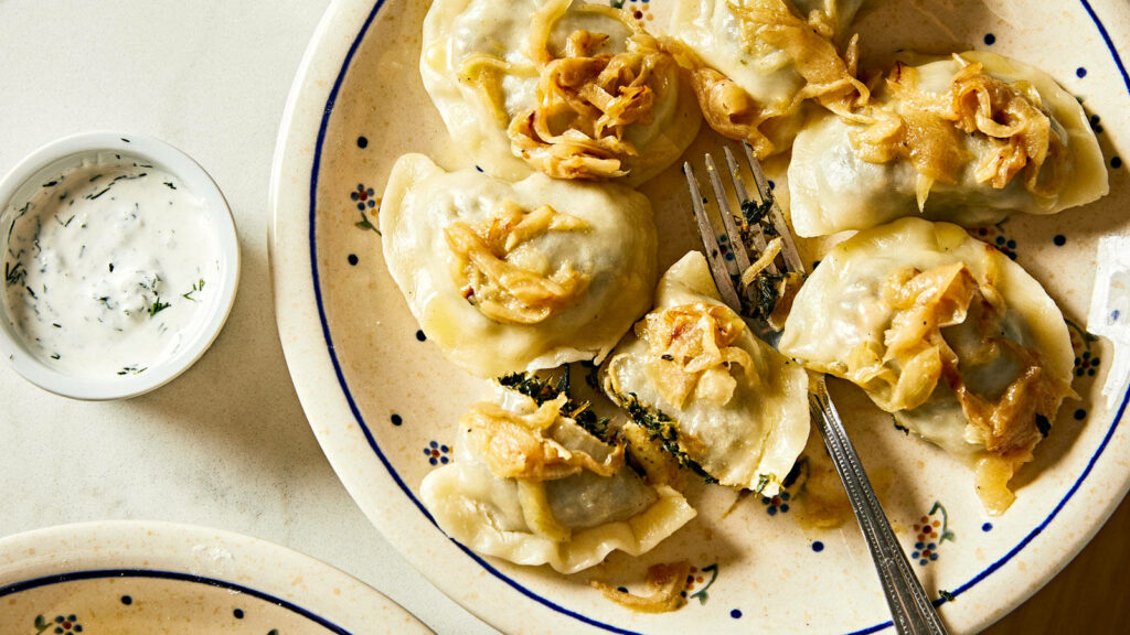 Delicious Pierogi Wallpaper: Freshly Made with Onions & Creamy Sauce