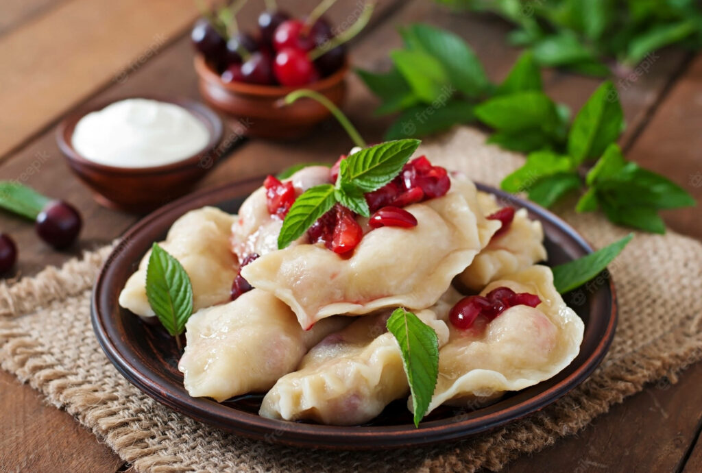 Delicious Pierogi with Cherries & Mint on Rustic Table - Wallpaper