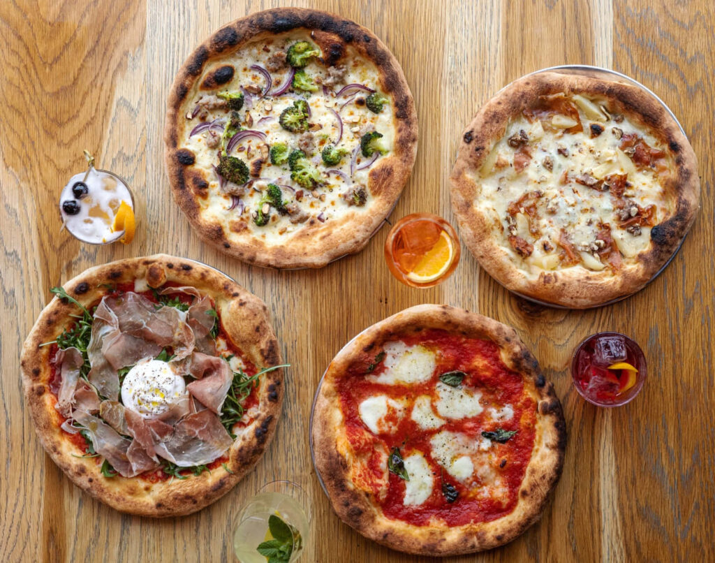 Colorful Pizza Wallpaper: Tasty Pizzas & Beverages on Wooden Table