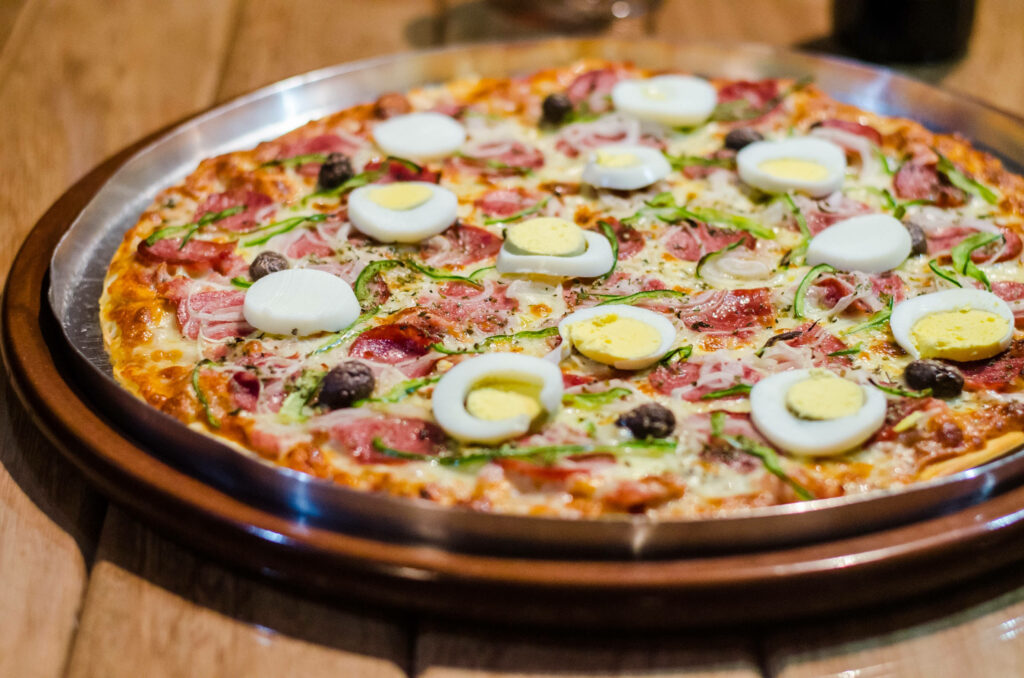 Delicious Pizza Wallpaper: Boiled Eggs, Olives & Cheese Delight