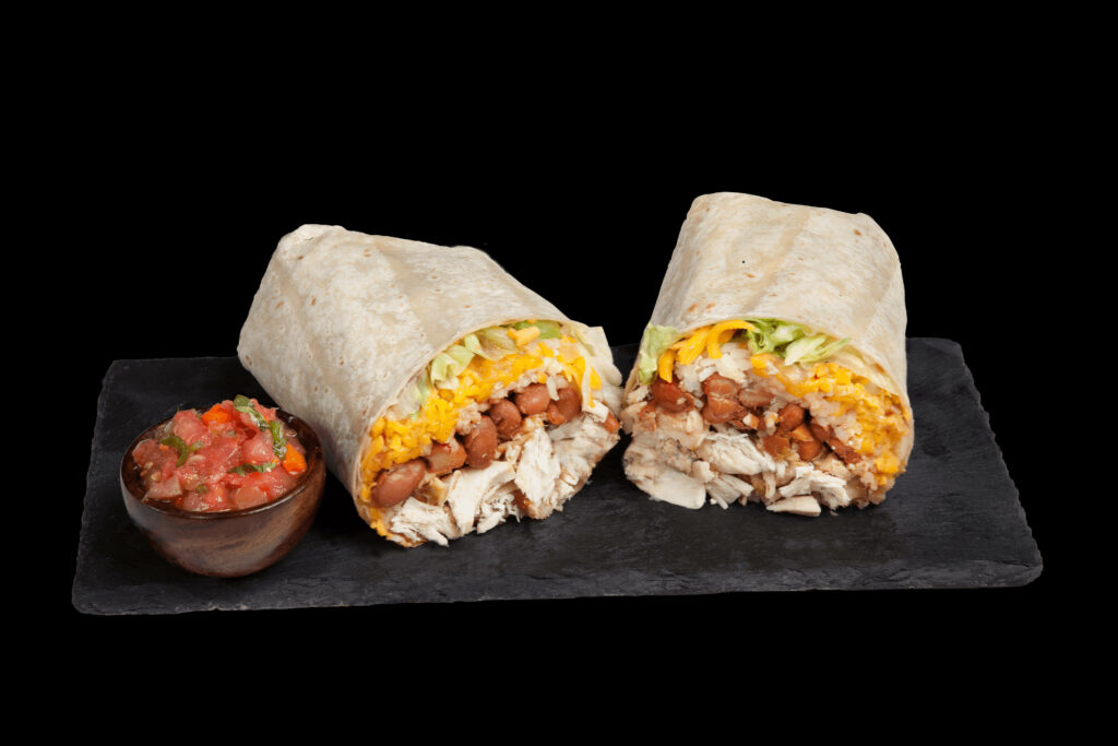 Closeup of sliced pork sausage burrito with beans cheese lettuce rice and fresh salsa on stone slab Wallpaper