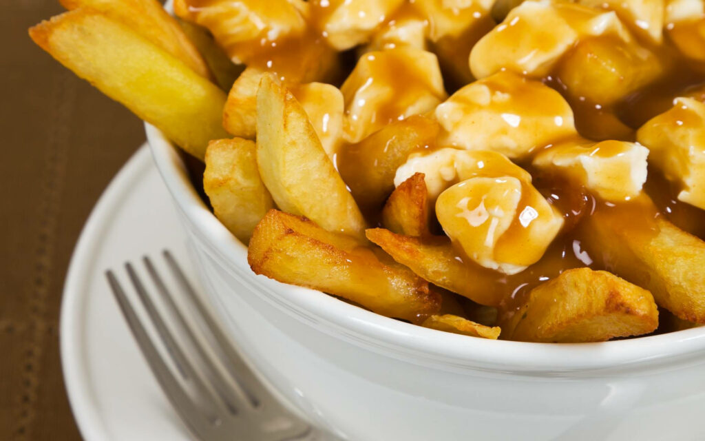 Delicious Poutine Close-Up: Golden Fries & Cheese Curds Wallpaper