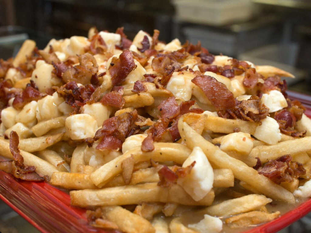 Delicious Poutine Wallpaper with Cheese Curds and Crispy Bacon Bits
