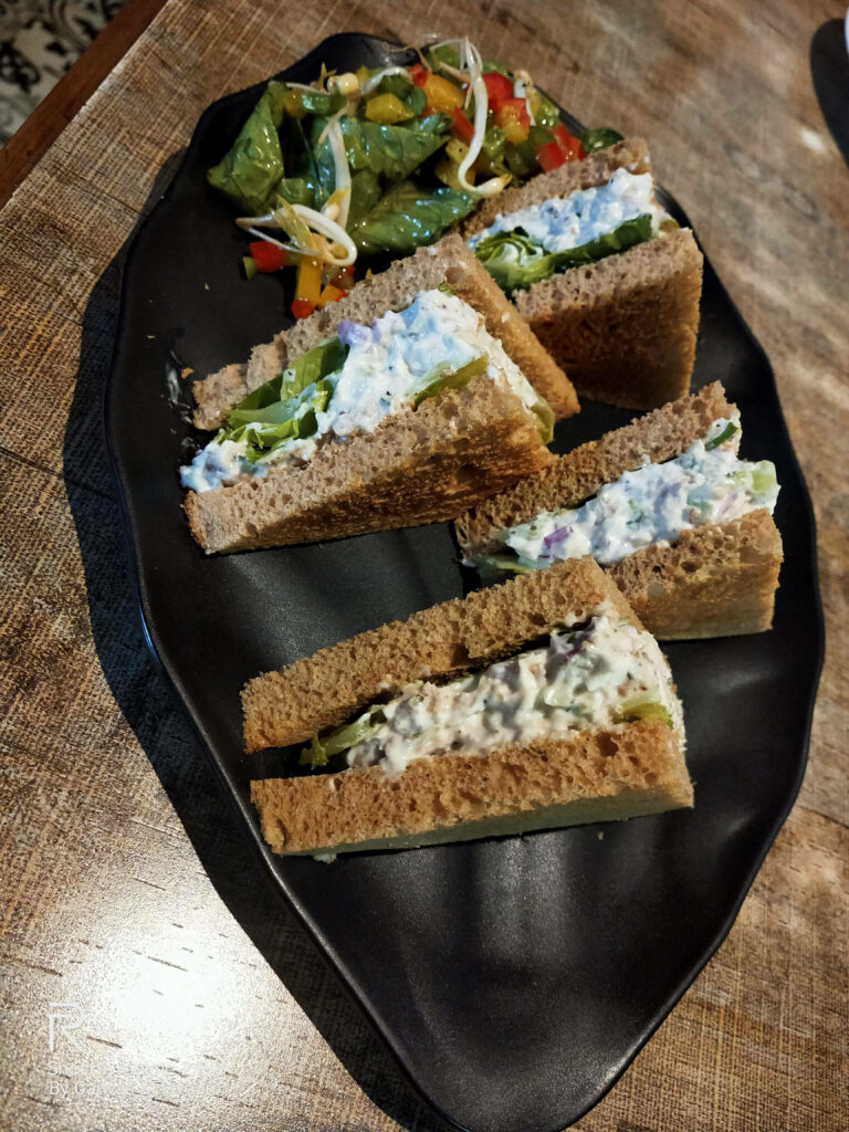 Delicious Sandwich on Black Plate with Colorful Veggie Salad Wallpaper