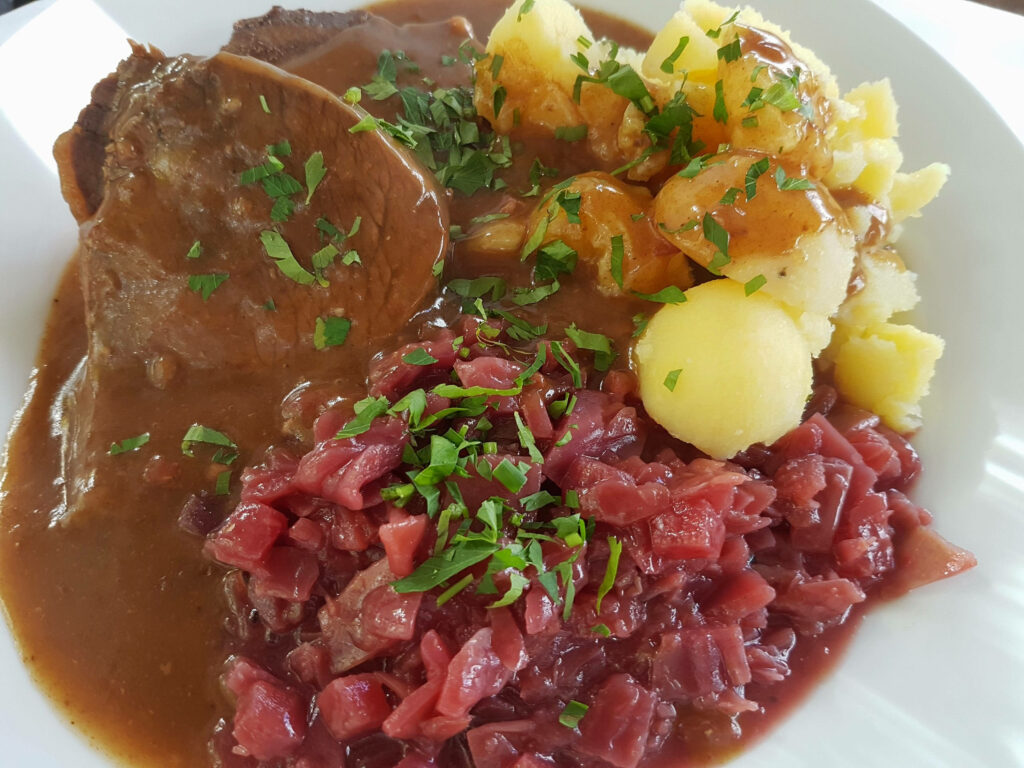 Delicious Sauerbraten Wallpaper: German Dish with Potatoes & Gravy