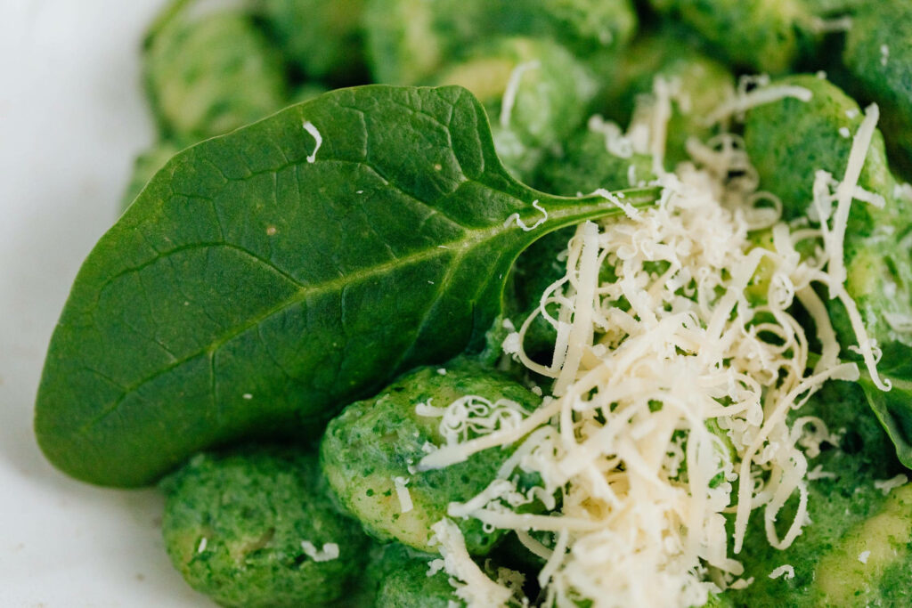 Delicious Spinach Gnocchi Wallpaper with Cheese & Fresh Garnish