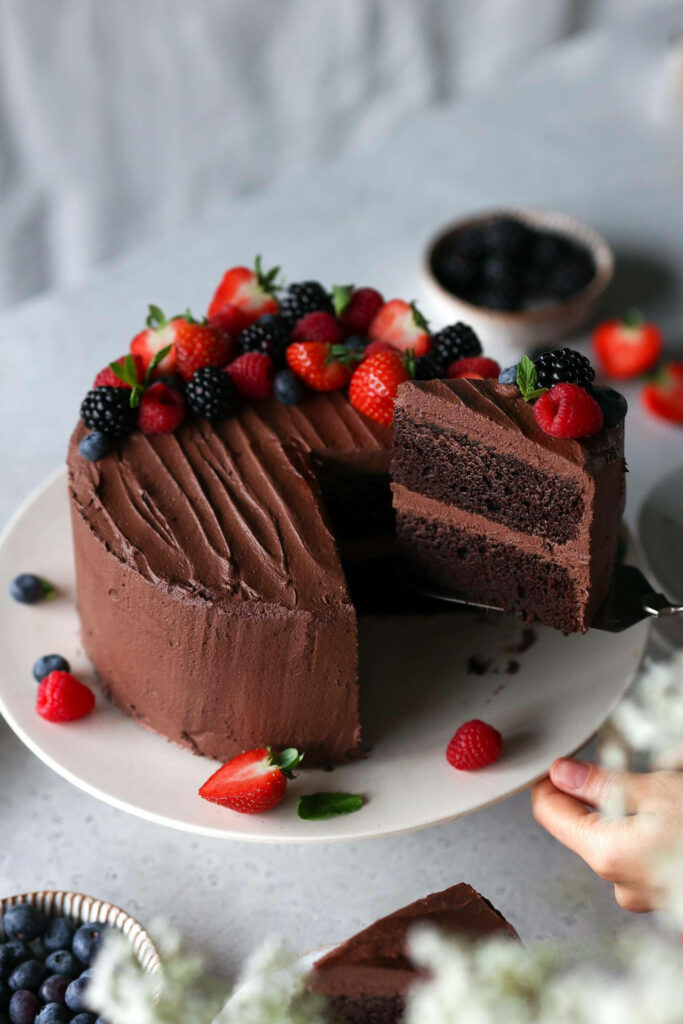 Two-layer chocolate cake with fresh strawberries raspberries blackberries and blueberries dessert wallpaper