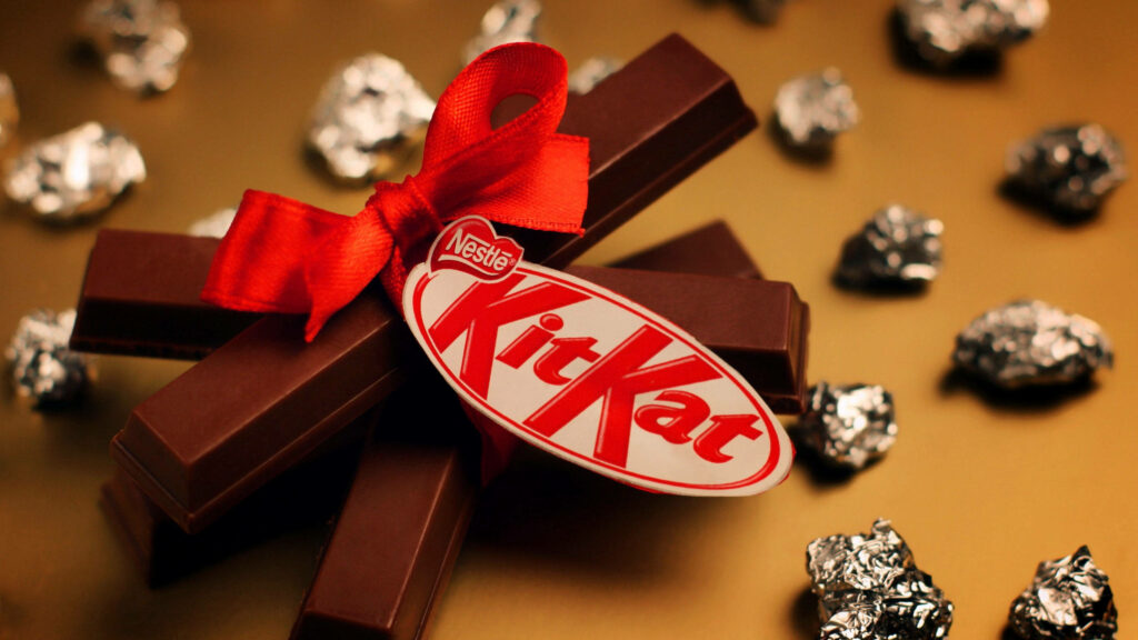 Kit Kat Chocolate Bars Wallpaper with Red Ribbon on Gold Background