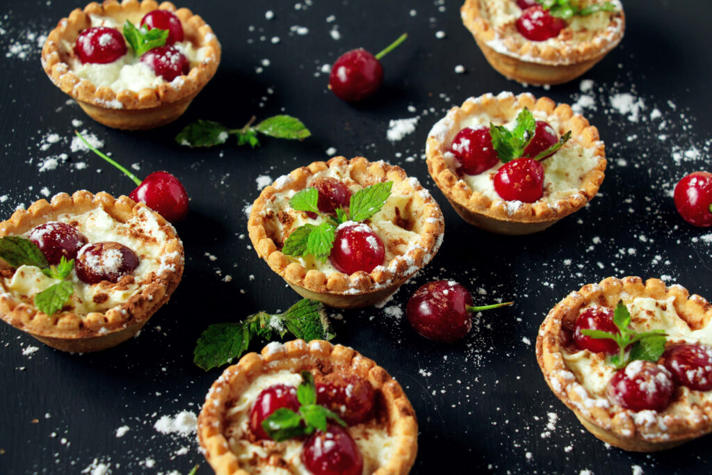 Vibrant Mini Tarts Wallpaper: Berries & Mint on Dark Background