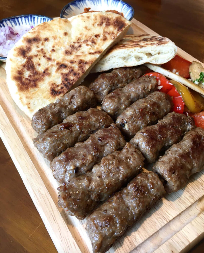 Grilled Ćevapi Wallpaper: Tasty Pita & Fresh Veggies Background
