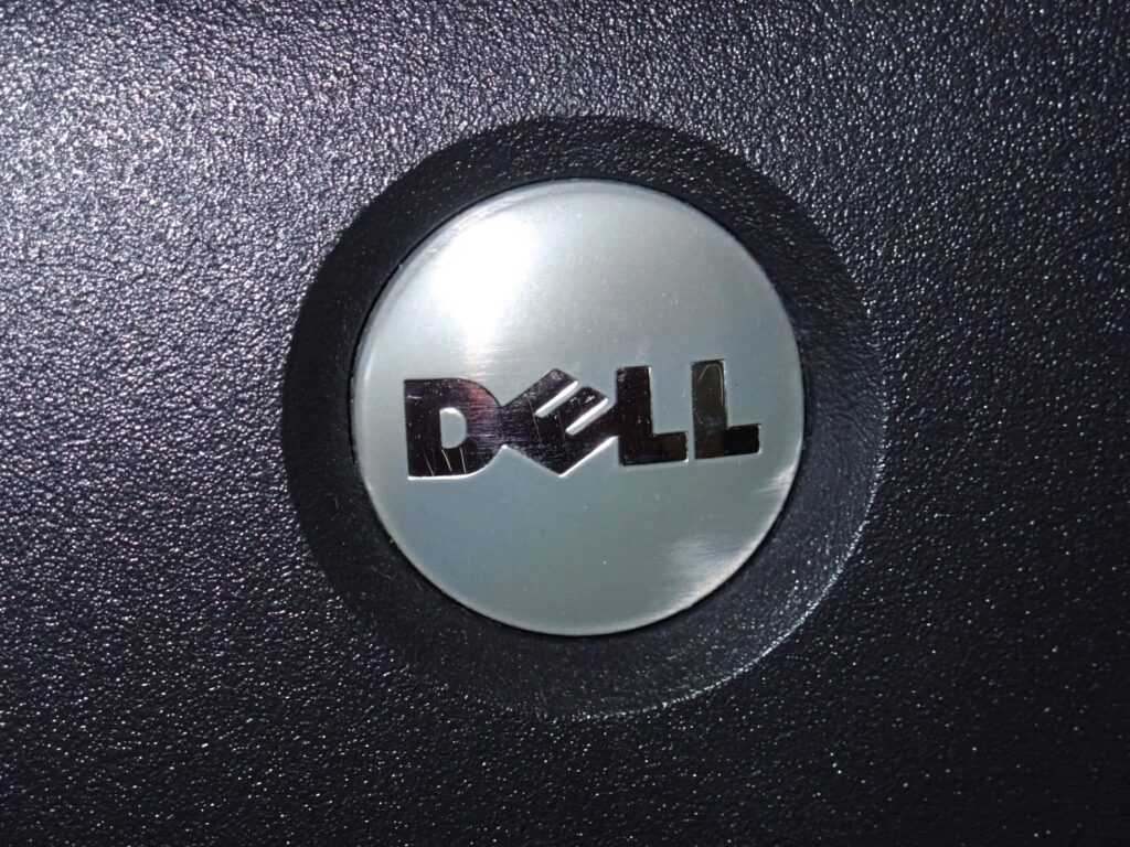 Dell logo on sleek metallic surface with textured dark background modern tech wallpaper