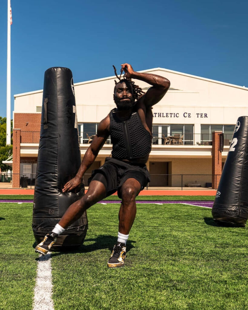 Demario Davis training on green football field navigating tackling dummies under clear blue sky Wallpaper