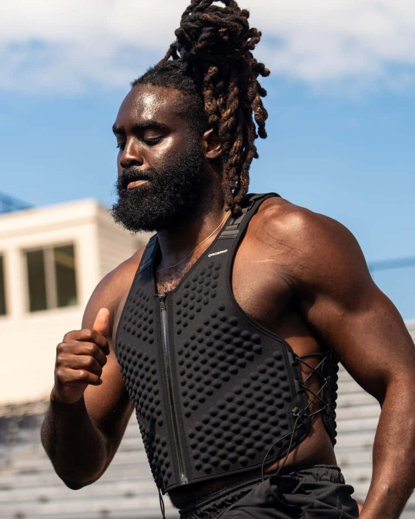 Demario Davis training outdoors in black vest under bright sky showing strength and focus Wallpaper