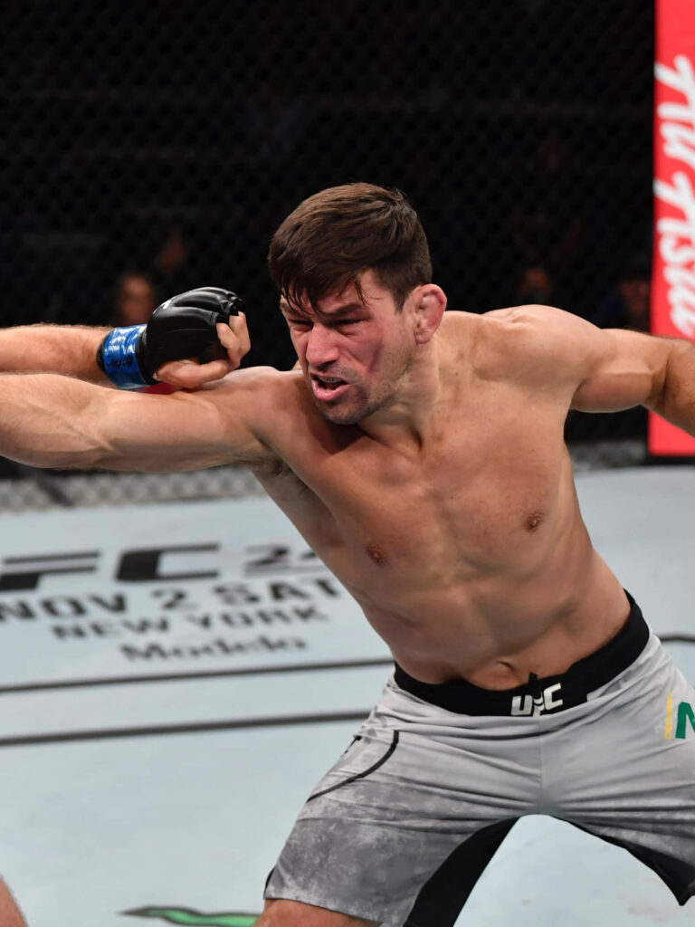 Demian Maia UFC fighter delivering powerful punch inside octagon with intense focus and strength Wallpaper