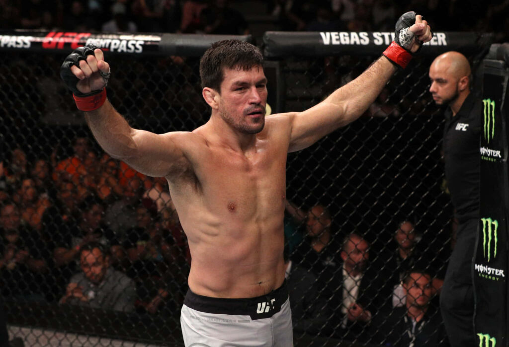 Demian Maia celebrates UFC Fight Night victory in octagon with intense crowd and dramatic lights Wallpaper