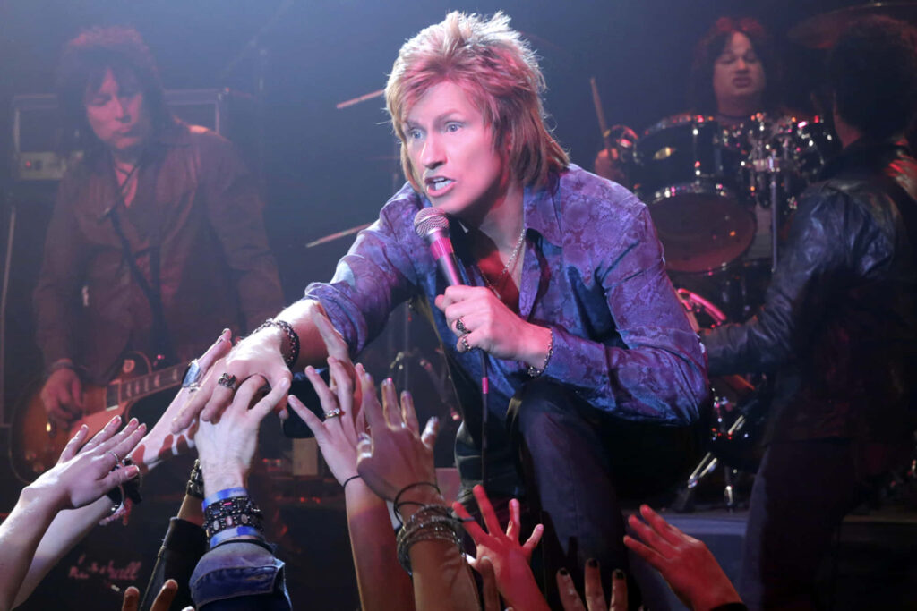 Denis Leary performing live on stage with energetic crowd and dramatic rock concert lighting Wallpaper