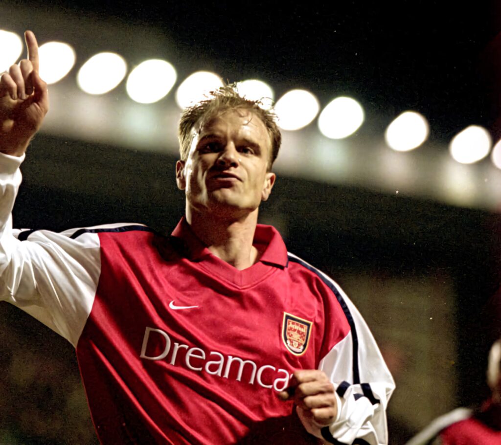 Dennis Bergkamp in red Arsenal jersey celebrating goal under stadium lights football wallpaper