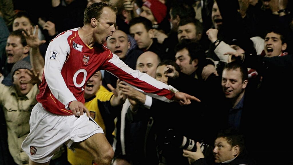 Dennis Bergkamp celebrates scoring for Arsenal against Manchester United with cheering fans Wallpaper