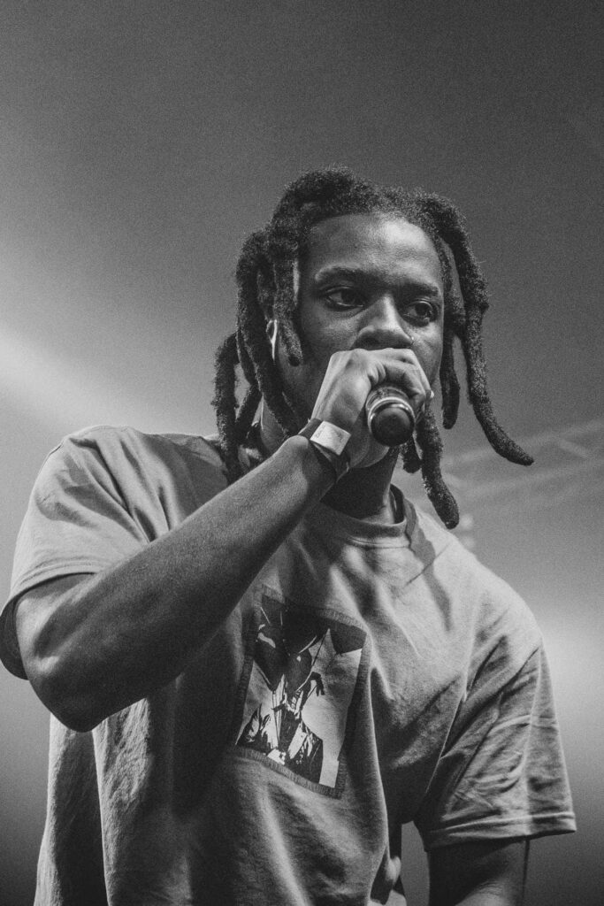 Denzel Curry intense live rap performance black and white wallpaper dramatic lighting concert