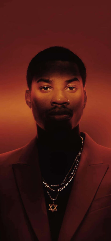 Denzel Curry portrait with intense expression vivid red background gold chains dramatic lighting wallpaper