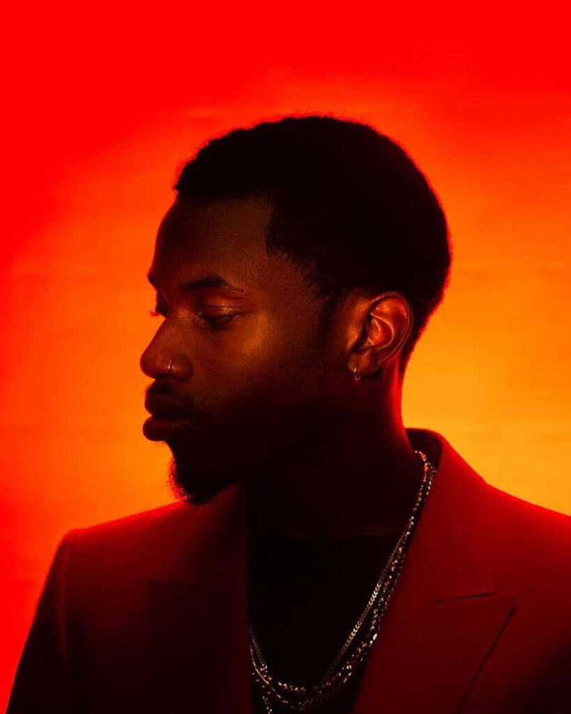 Denzel Curry red profile with jewelry vivid orange backdrop modern artistic wallpaper background