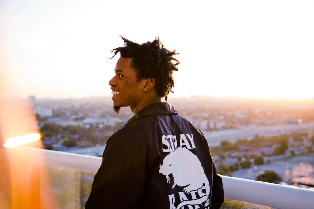 Denzel Curry rooftop silhouette at sunset golden light urban cityscape Stay Rats One jacket Wallpaper