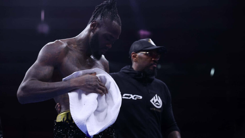 Deontay Wilder shirtless tired holding towel with trainer arena lights boxing resilience wallpaper