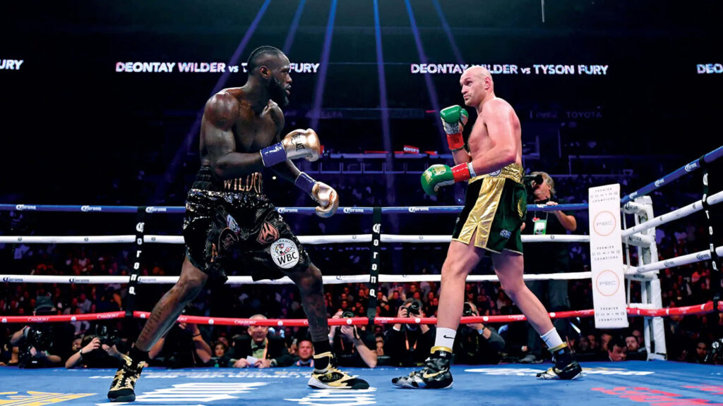 Deontay Wilder vs Tyson Fury intense boxing match in bright arena with energized crowd wallpaper